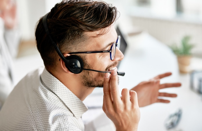 happy-call-center-agent-wearing-headset-while-talking-with-clients-working-office 1